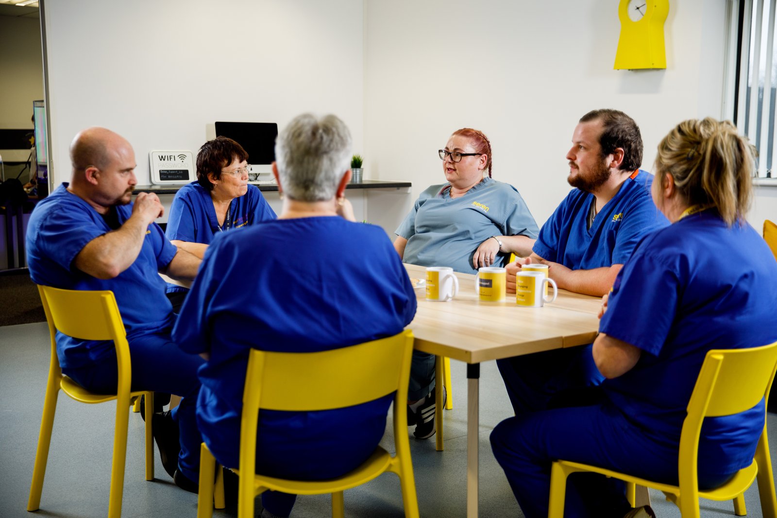 Seren care team in branded scrubs at office meeting